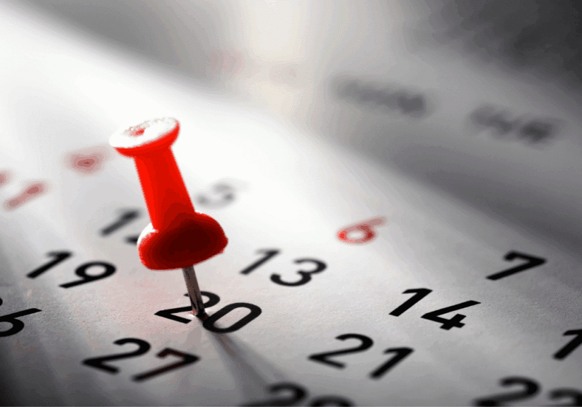 A calendar with a red pin in it.